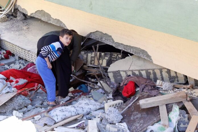 صورة رجل ينظر إلى مبنى متضرر عقب زلزال في مدينة دربندخان. رويترز أكو رشيد